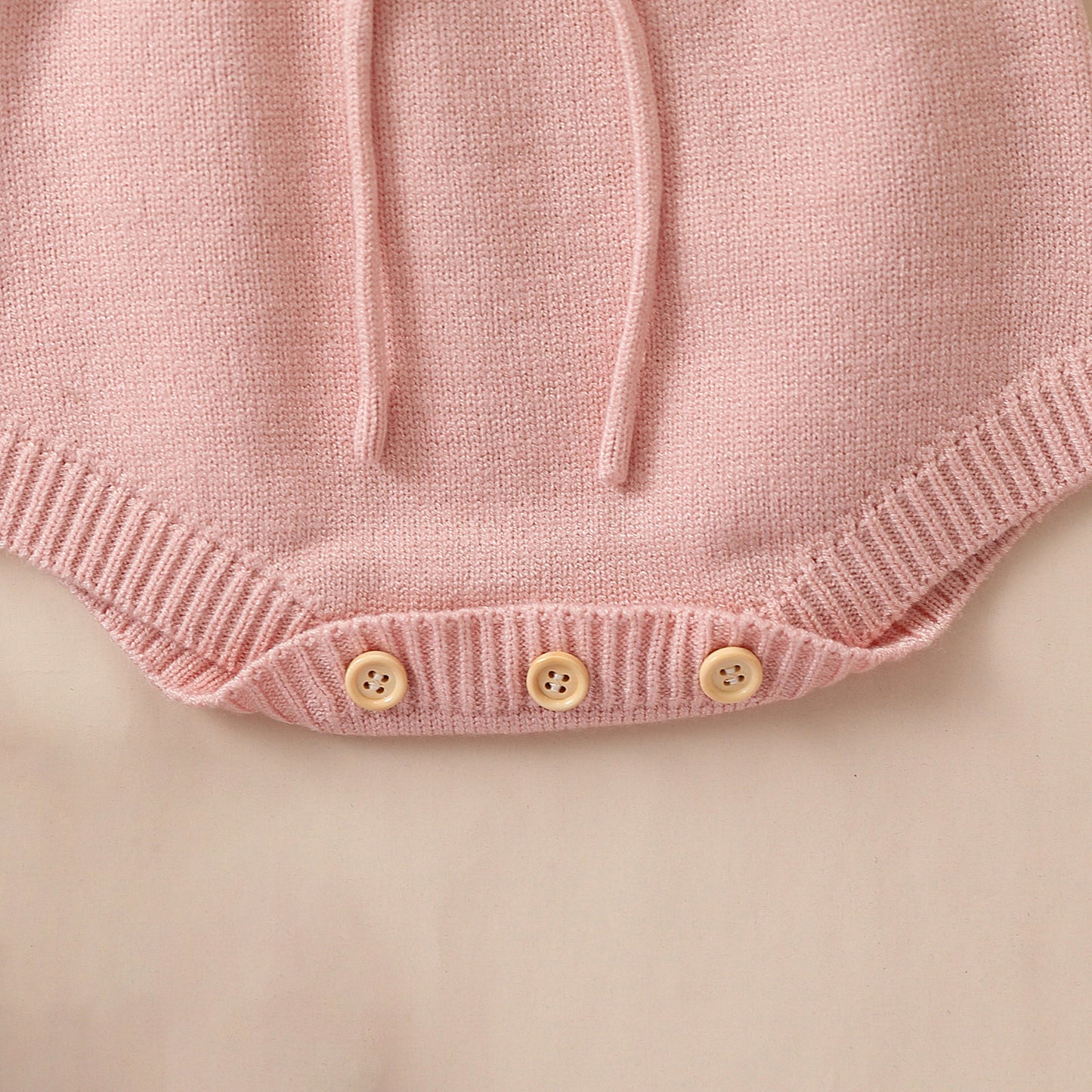 Pagliaccetto in maglia bimba con cuore in rilievo rosa