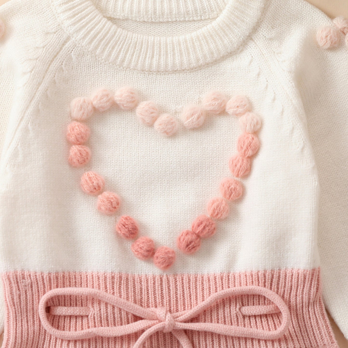 Pagliaccetto in maglia bimba con cuore in rilievo rosa