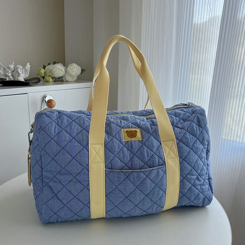 Borsa da viaggio trapuntata azzurra con manici gialli e patch orsetto